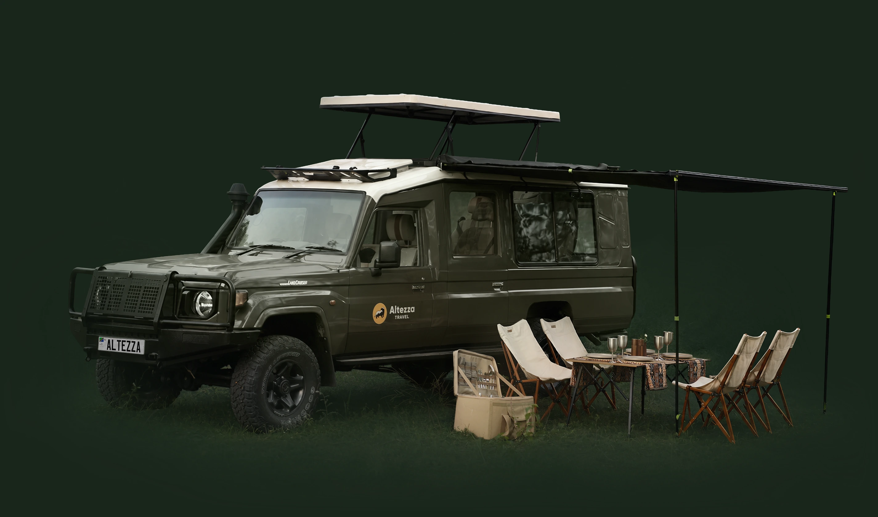 Véhicule de safari avec auvent, table, chaises et malle de pique-nique installés pour un déjeuner dans la brousse